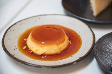 Karamelli puding pastayla çanak üzerinde sulu