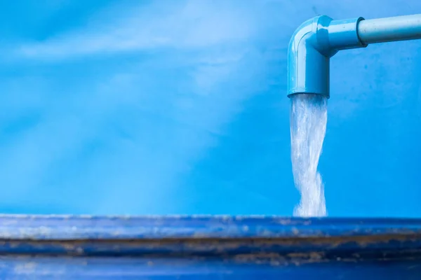 Голубая PVC труба с проточной водой в ведре — стоковое фото