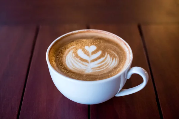 Heiße Latte Kaffeetasse Herzform auf Holztisch — Stockfoto