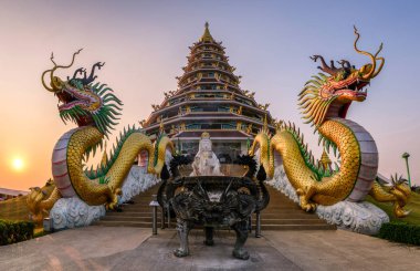 Gün batımında pagoda ejderha heykeli arasındadır