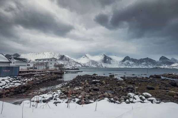 Cordillera nevada con cielo tormentoso en pueblo pesquero en la costa — Foto de Stock
