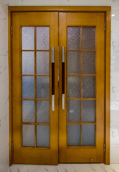 Porta in legno con vetro e maniglia a parete — Foto Stock
