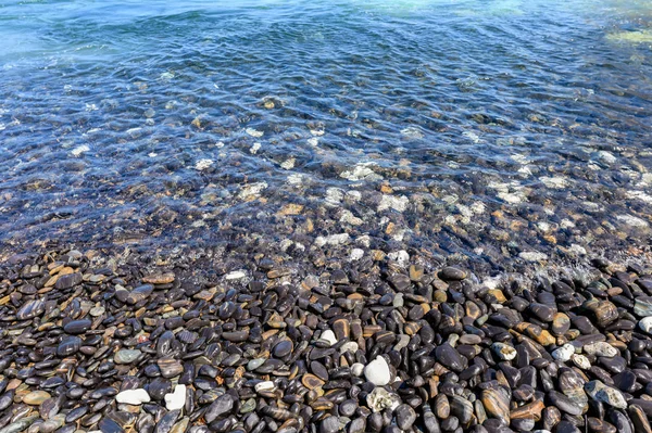 Kıyı şeridinde tropikal denizde doğal siyah taş