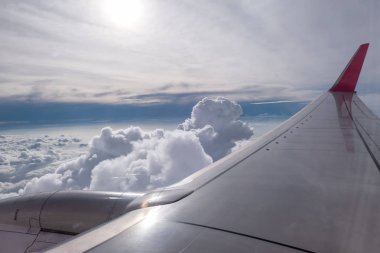 Gökyüzünde bulutlar üzerinde uçan uçak kanadı