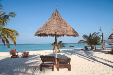 Tropikal plajda saman şemsiyesunda şezlong