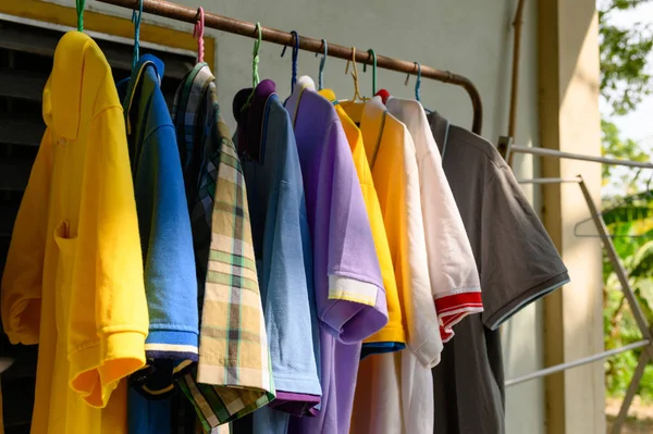 Chemise masculine colorée accrochée à la ligne de vêtements ensoleillée — Photo