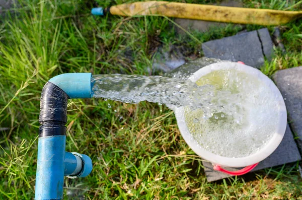 Agricultura tubería azul con chorro de agua subterránea en plantación — Foto de Stock