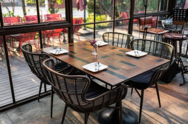 Modern sanayi binasında ahşap yemek masası ve sandalyeler.