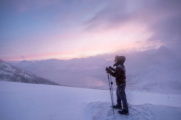 雪山の頂上に立つトレッキングポールを持つ男性登山家 — ストック写真