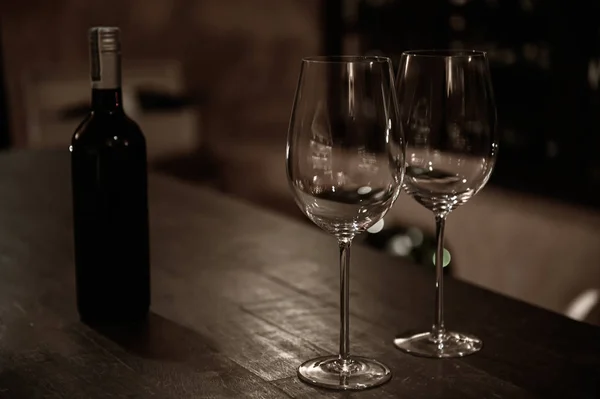 Dois copos de vinho com garrafa de vinho em barra de madeira — Fotografia de Stock