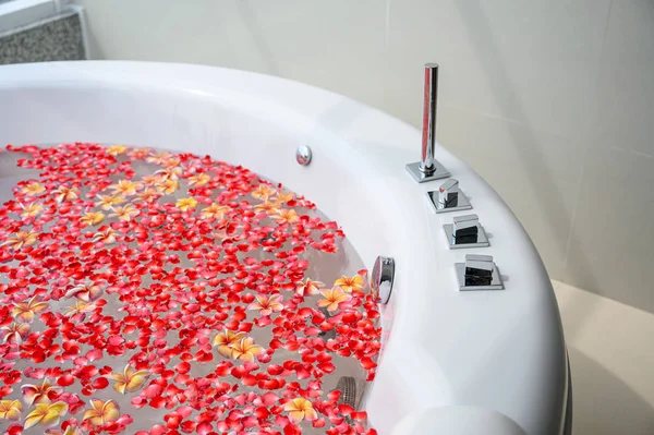 Роскошная ванна с цветным цветком в воде с видом на море — стоковое фото