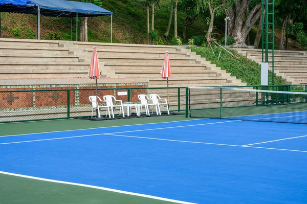Campo de caucho sintético en pista de tenis con silla y sombrilla — Foto de Stock