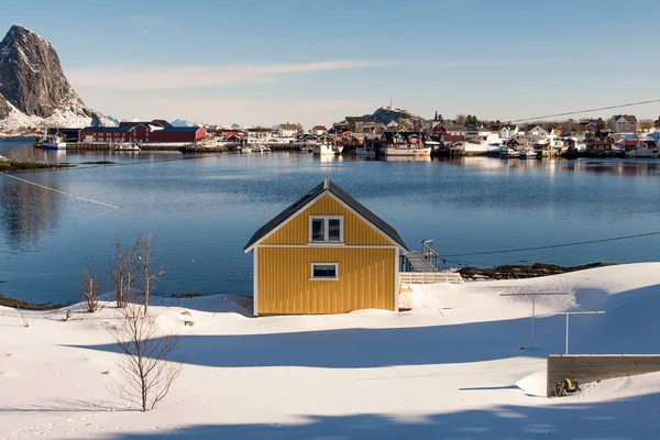 Geel huis op sneeuw in vissersdorp aan de kust — Stockfoto