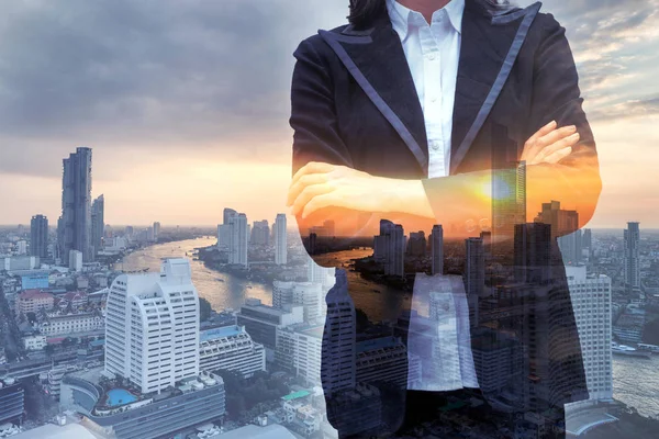 Leader business woman arms crossed in the city with river at sun