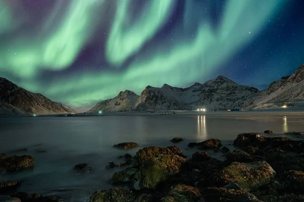 Aurora Borealis a csillagok felett hegyvonulat a tengerparton — Stock Fotó