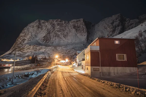 Noors dorp op landweg met licht schijnt en sneeuw mo — Stockfoto