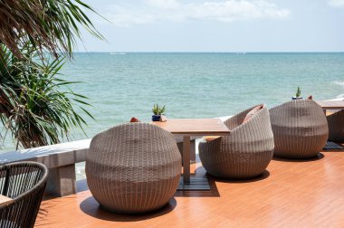 Tropikal deniz ile ahşap masa ile modern örgü sandalyeler