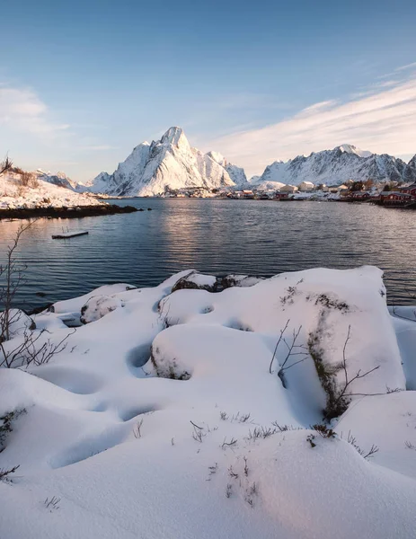 Heap Snow met vissersdorp in besneeuwde berg aan de kust — Stockfoto
