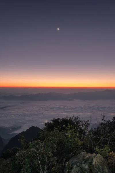 Восход солнца на горном хребте с туманом и луной — стоковое фото
