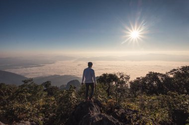 Vahşi yaşam sığınağında dağın tepesinde duran bir adam gezgini