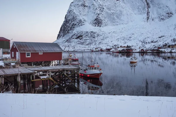 Bateau de pêche ancré sur une jetée avec village rouge en hiver à Lofo — Photo