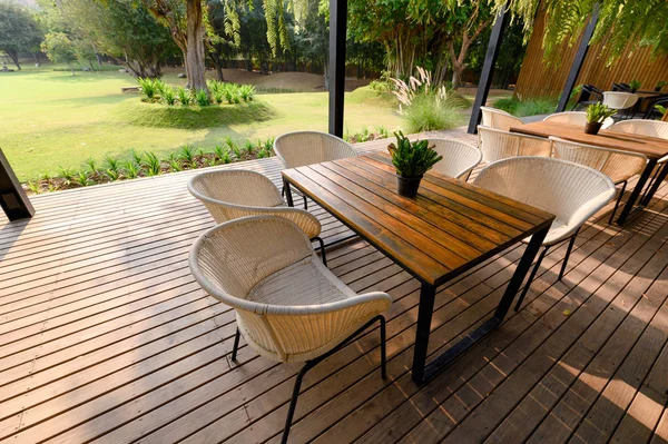 Wooden chair with table and green flora on patio — Stock Photo, Image