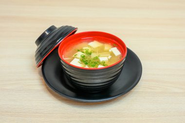 Kapaklı siyah bardakta tofu ve sebze ile Miso çorbası