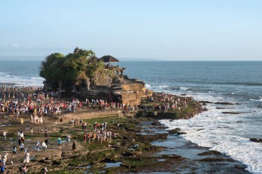 Kıyı şeridindeki Tanah Lot tapınağında tatile çıkan turistler