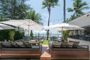 Beyaz şemsiye ve deniz manzaralı yemek masası