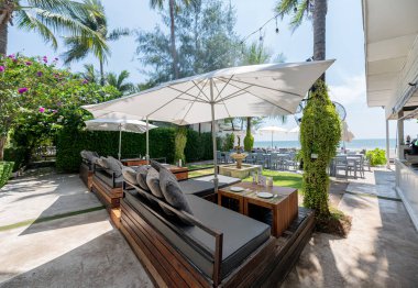 Beyaz şemsiye ve deniz manzaralı yemek masası