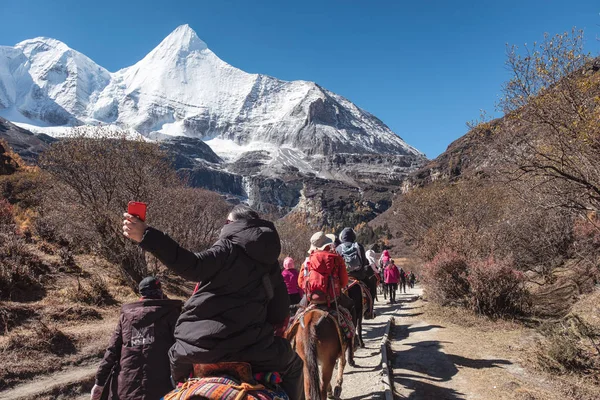 Grupo de turistas equitação cavalo em vale sagrado com Yangmaiyong — Fotografia de Stock