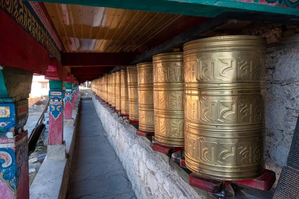 Rows of ancient traditional golden wheels of tibetan temple — Stock Photo, Image