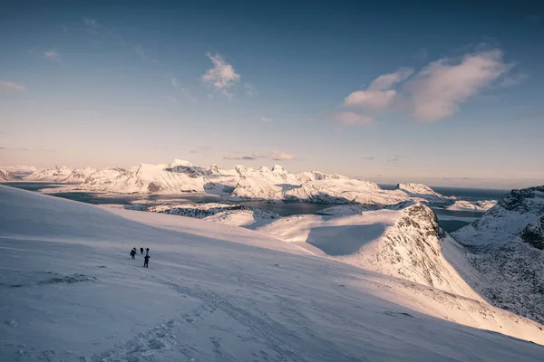 夕暮れ時の雪の丘の上のグループ旅行者の旅 — ストック写真