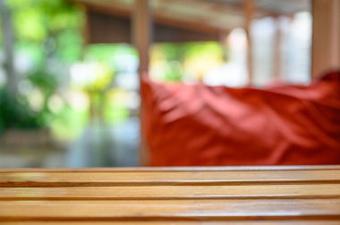 Oturma odasında bulanık kırmızı yastık ile Ahşap masa