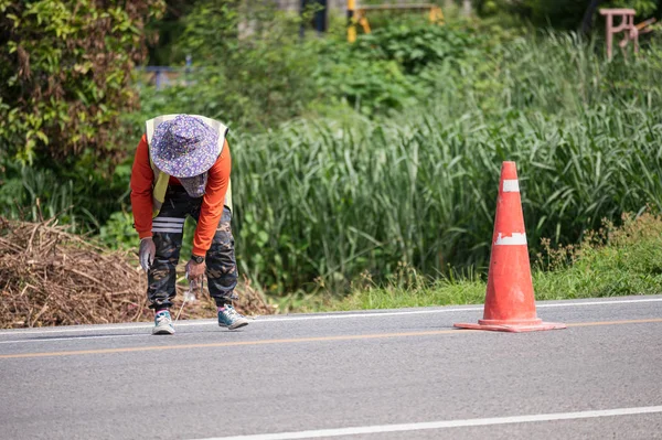 Trabajador vistiendo uniforme está rayando con la medición en la carretera — Foto de Stock