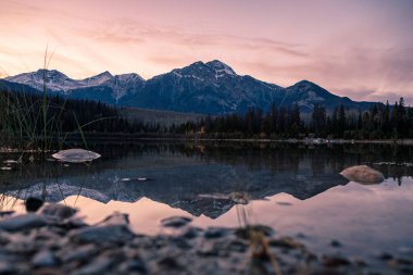 Kanada Jasper Ulusal Parkı 'nda gün batımında Patricia Gölü' ne yansıyan Rocky dağları