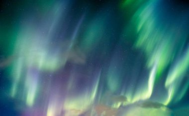 Aurora borealis, Kuzey ışıkları Kuzey Kutup Dairesi 'nde gece gökyüzünde yıldızla dönüyor.