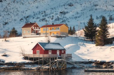 Norveç 'in Lofoten Adaları' nda kışın kıyı şeridinde bulunan Ahşap İskandinav kırmızı evi
