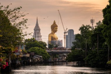 Bangkok, Tayland 'da nehir kenarındaki geleneksel toplulukta pagoda' lı büyük altın Buda.