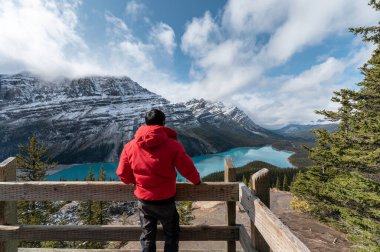 Kanada Banff Ulusal Parkı 'ndaki Peyto Gölü manzaralı kışlık ceketli adam.