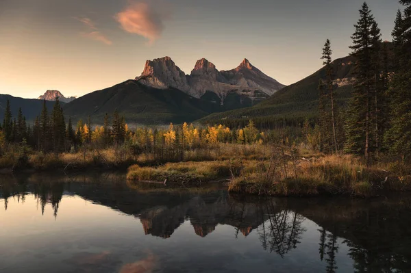 Üç Kız Kardeş Dağının Manzarası Kanada 'daki Banff Ulusal Parkı Canmore' da sonbahar ormanlarını yansıtıyor.
