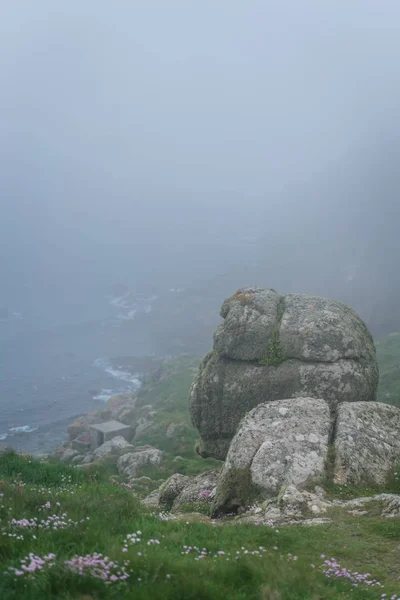 Large boulders on the coast of the Lands End - the most westerly point of England which is a popular tourist attraction, Penwith peninsula, Penzance, Cornwall