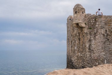 Budva, Karadağ - Nisan 2018: yüksek eski kasaba fort duvarda oturan yalnız turist