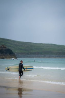 St. Ives, İngiltere - Mayıs 2018: sae yürüyüş ve sörf tahtasına, Cornwall, İngiltere'de taşıyan eğitmen sörf