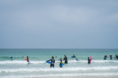 St. Ives, İngiltere - Mayıs 2018: Deniz, Cornwall, İngiltere'de öğretim elemanları ile sörf pratik sörf adepts Grup