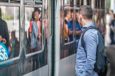 Londra, İngiltere - Temmuz 2018: adam platformda, İngiltere'de gelen Cross'taki tren beklerken kulaklıklar müzik dinlemek