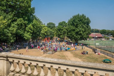 Londra, İngiltere - Temmuz 2018: sıçramasına, püskürtme ve Wimbledon yağmurlama Park'ta yer bir havuzda atlama eğlence çocuk