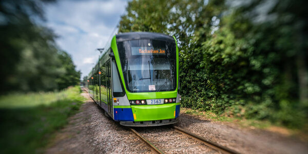 London, England -  July 2018 : Modern tramway on tracks going through the forest