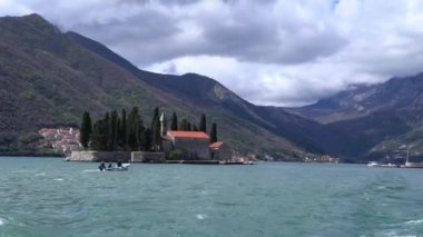 Kotor Koyu'ndaki, Perast, Karadağ kayalarda Our Lady Bazilikası uzak Yelkenli tekne.