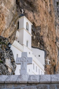 Çapraz beyaz şaşırtıcı bulunduğu ünlü dönüm noktası Ostrog Ortodoks Manastırı Karadağ'ın önünde taş duvar